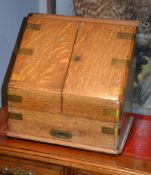 An oak and brass bound slope front stationary box, 40cm high, 39cm wide, 29cm deep