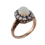 A diamond and opal cluster ring , the central oval cabochon opal within a surround of old brilliant