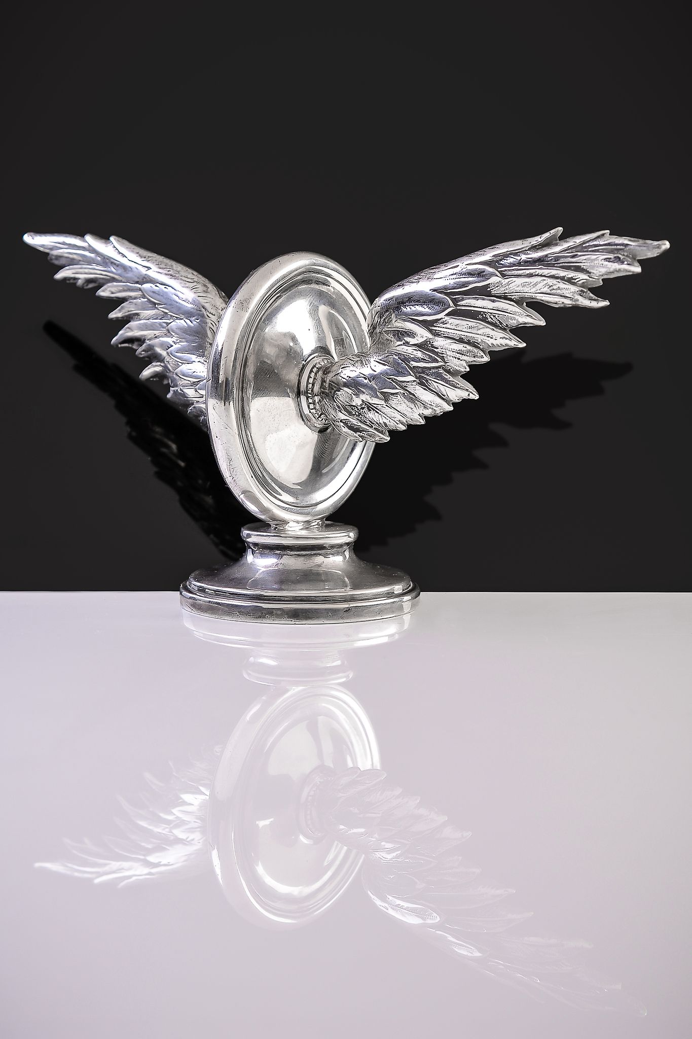 A rare silver car mascot by Garrard & Co. Ltd, London 1919, formed as a winged wheel, 20cm (8in)