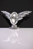 A rare silver car mascot by Garrard & Co. Ltd, London 1919, formed as a winged wheel, 20cm (8in)