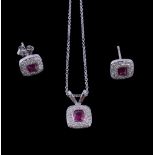 A ruby and diamond pendant, the cushion cut ruby collet set within a surround of brilliant cut