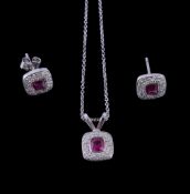 A ruby and diamond pendant, the cushion cut ruby collet set within a surround of brilliant cut