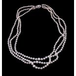 A three strand cultured pearl necklace by Mikimoto, composed of graduating cultured pearls, to the