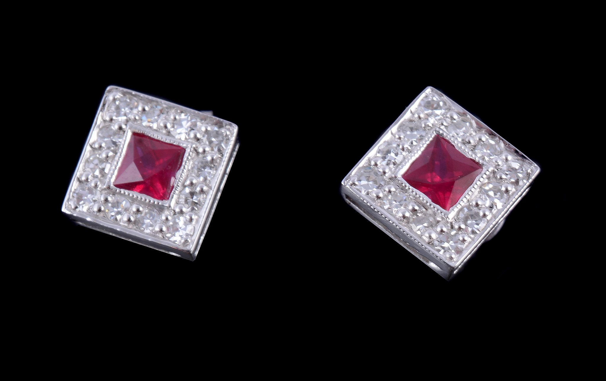 A pair of diamond and ruby square cluster ear studs , each stud centred with a step cut ruby within