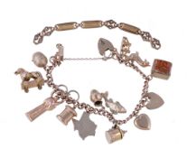 A 9 carat gold charm bracelet, composed of curb links, suspending various charms, including: a