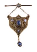 A sapphire and pearl pendant, the shield shaped panel with applied scroll and bead work, set with