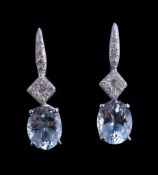 A pair of aquamarine and diamond earrings, the oval cut aquamarines claw set below brilliant cut
