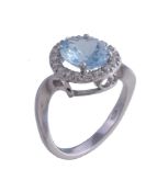 An aquamarine and diamond cluster ring, the oval cut aquamarine claw set within a surround of