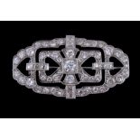 An Art Deco diamond brooch, circa 1930, the pierced lobed geometric panel millegrain set with