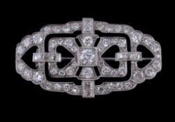 An Art Deco diamond brooch, circa 1930, the pierced lobed geometric panel millegrain set with