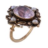 A mid 19th century pink topaz and half pearl ring, circa 1840, the central oval cut pink topaz in a