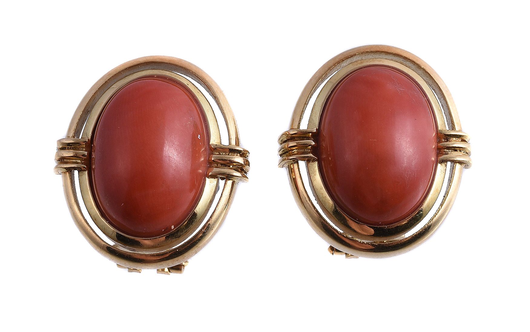 Ω A pair of coral earrings, the oval cabochon coral within a polished surround, with post fittings,