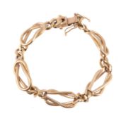A gold coloured bracelet, composed of lover's knot links, with flattened curb links in between,