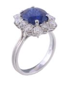 A sapphire and diamond cluster ring, the central oval cut sapphire, estimated to weigh 3.36 carats,