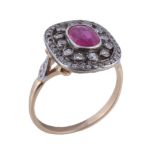 A diamond and ruby cluster ring , the central oval cut ruby within a pierced diamond set surround,