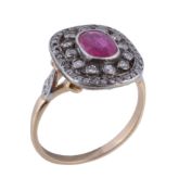 A diamond and ruby cluster ring , the central oval cut ruby within a pierced diamond set surround,