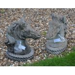 A pair of composition stone horse head pier finials, each 50cm high