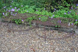 A pair of wrought iron demi-lune tree seats, 114cm in length
