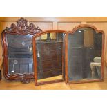 A carved walnut wall mirror, 85cm high, 54cm wide, and two further wall mirrors - previously