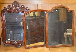 A carved walnut wall mirror, 85cm high, 54cm wide, and two further wall mirrors - previously