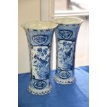 A pair of Delft blue and white vases, of octagonal section decorated with floral reserves. 33cm high