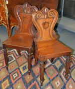 A pair of William IV mahogany hall chairs, circa 1835, each with scrolled back with central vacant