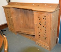 An Arts and Crafts pine side cabinet, with central bookcase section flanked by pierced cupboard