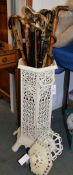 A white painted cast iron stick stand, of hexagonal section and a quantity of various sticks