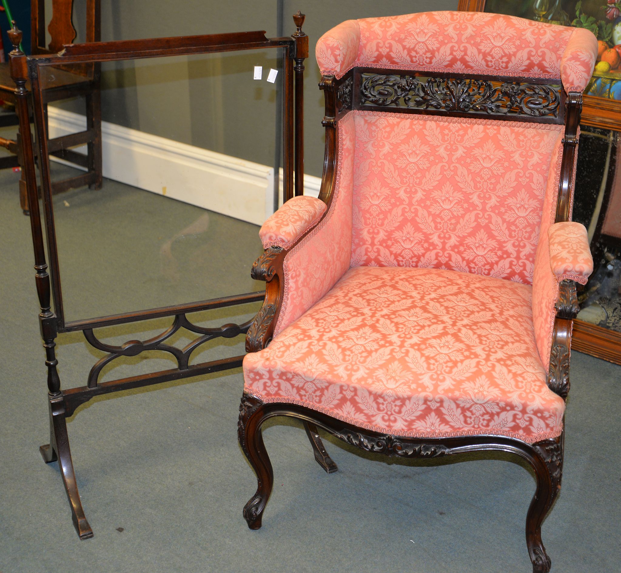 A late Victorian pink upholstered armchair with carved show frame, and a mahogany and glazed fire