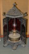 A Victorian cast iron conservatory heater, with oil lamp burner with a red glass funnel, 65cm high