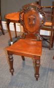 A Victorian mahogany hall chair, with pierced acanthus scrolls surrounding the shield back with