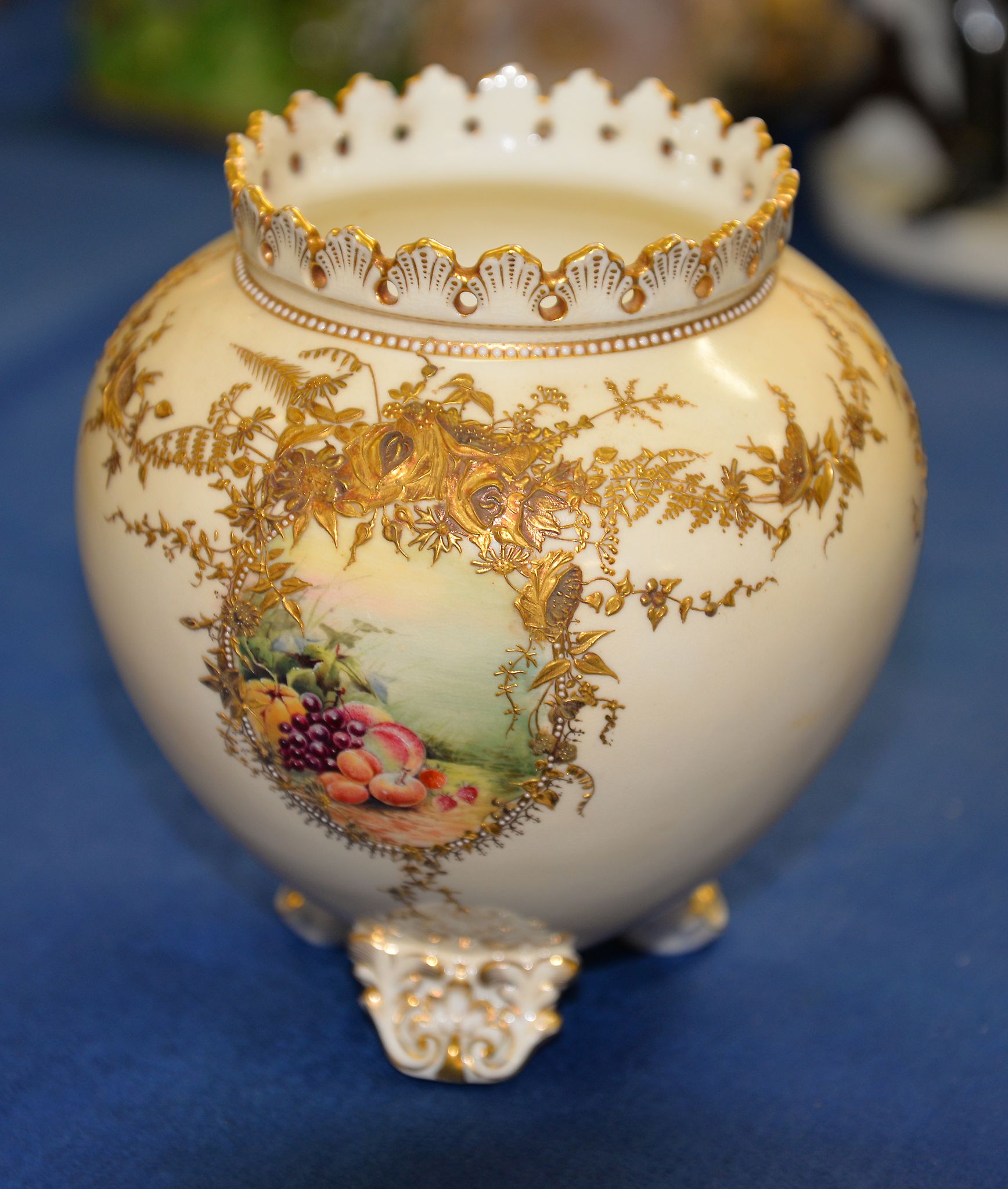A Coalport pale cream ground ovoid vase, late 19th century, painted with panels of fruit and