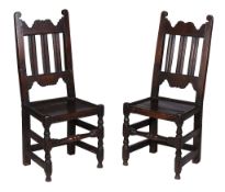 A pair of Charles II oak backstools, circa 1660, each rectangular back with scroll terminals centred