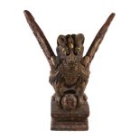 A large Balinese giltwood figure of a mythological beast, Garuda, on square waisted base, the