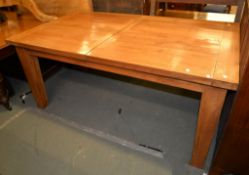 An oak extending dining table, 20th century, with additional hinged leaf insert swivelling when