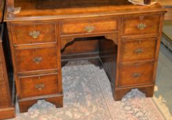 A walnut and mahogany banded kneehole desk, in George III style, the quarter book-matched top