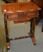 Ω A Victorian rosewood work table, the hinged top enclosing drawers above a slide, 67cm high, 52cm