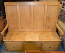 A pine settle, late 19th century, with panel back above seat with central locker compartment and two