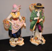 A pair of continental figures of street vendors, 24cm high