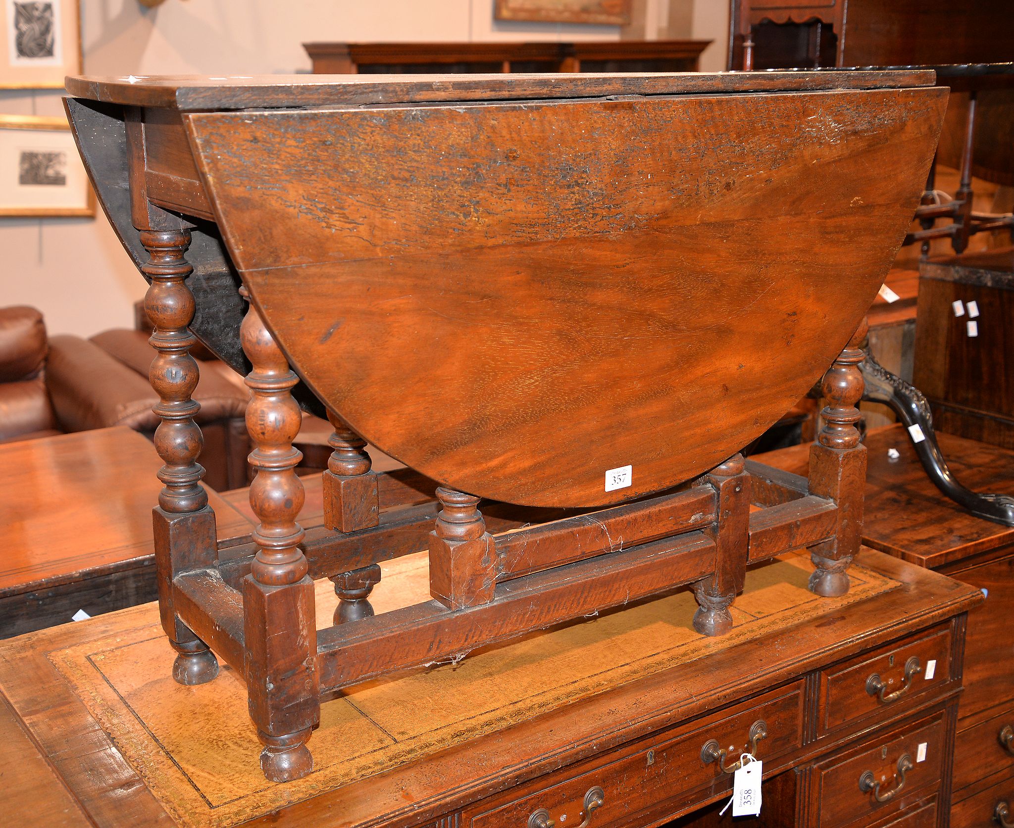 An oak and walnut gate leg table, 71cm high, the top 104cm x 125cm extended