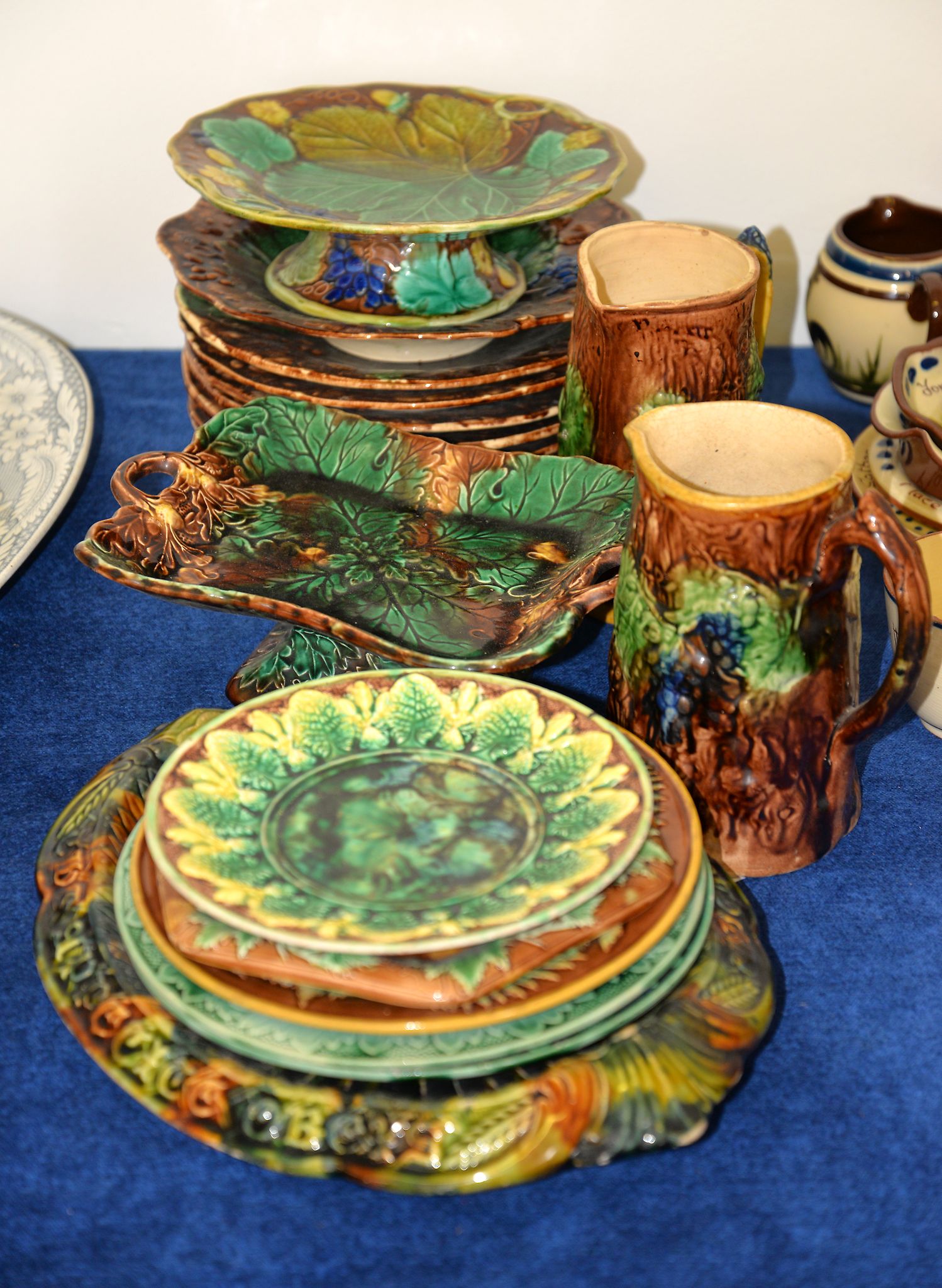 An assortment of British Majolica to include a pair of jugs, 17cm high, an oval bread plate, 33cm