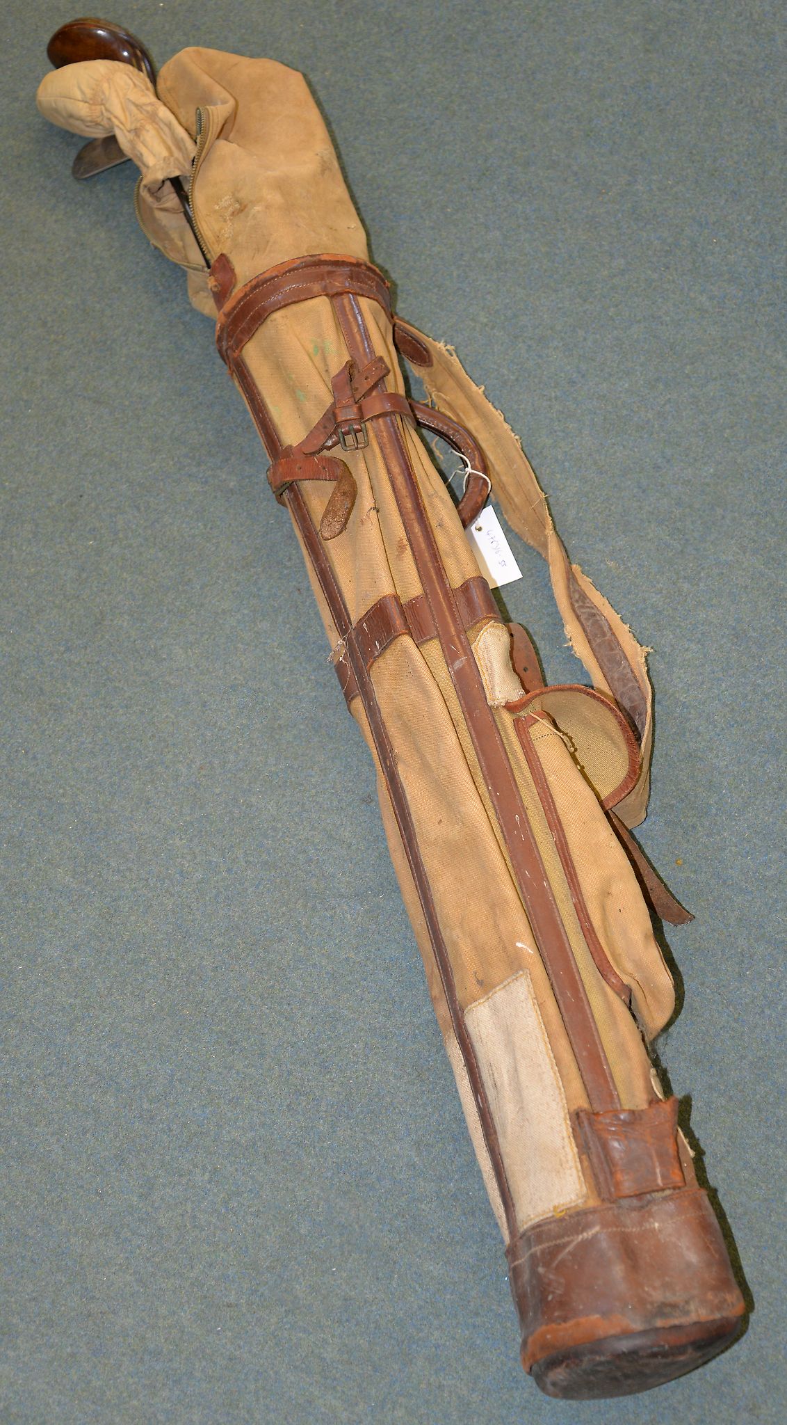 A part set of golf clubs in a leather and canvas bag Provenance: Removed from an Oxfordshire Manor