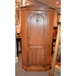 An oak corner wardrobe in Arts and Crafts taste, 196cm high