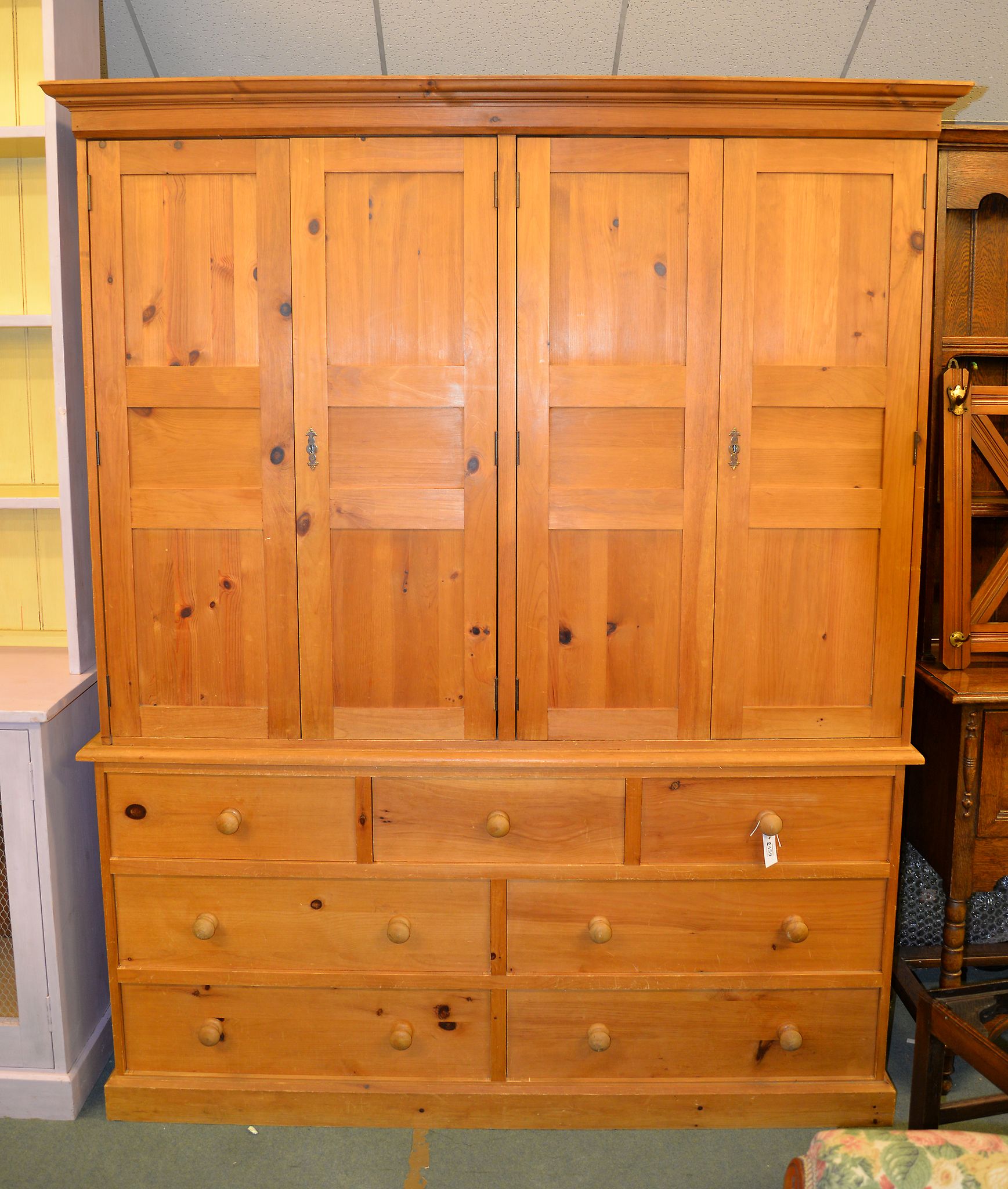 A pine cupboard, with four doors above drawers, 207cm high, 166cm wide