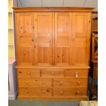 A pine cupboard, with four doors above drawers, 207cm high, 166cm wide