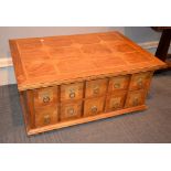 A modern mixed wood parquetry coffee table, the base with an arrangement of drawers to each opposing