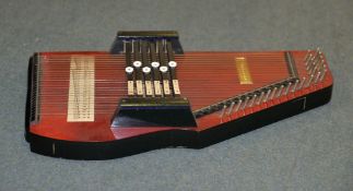 A stained wood Autoharp (zither), and an associated zither playing manual