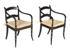 A pair of Regency ebonised and parcel gilt armchairs, circa 1815, each rectangular back with twin