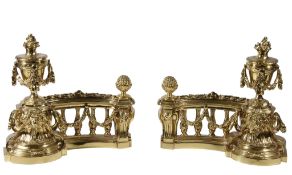 A pair of gilt metal chenets in Louis XVI style, circa 1900, each with swagged urn above festooned
