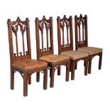 A set of four Victorian Gothic Revival oak side chairs , each with lancet arched backs, above